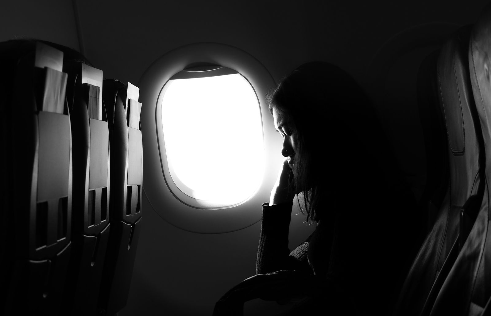 Traveller silhouetted against an aircraft window